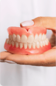 A woman holding a set of dentures