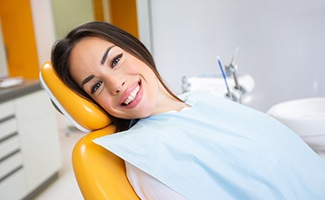 Smiling woman lying back in dental chair